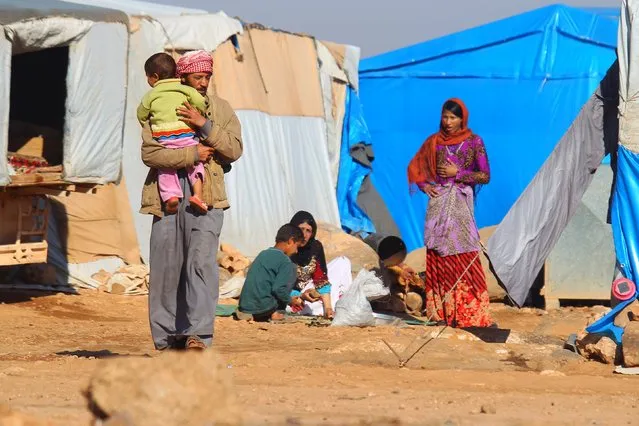 Internally displaced Syrians stand outside tents at a makeshift refugee camp in Sinjar town, in Idlib province, Syria November 20, 2015. (Photo by Ammar Abdullah/Reuters)