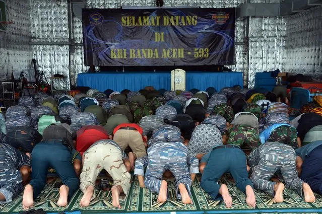 Indonesian navy personnel pray onboard the navy vessel KRI Banda Aceh during their efforts to lift the tail of AirAsia Flight QZ8501, in the Java Sea January 9, 2015. Indonesia AirAsia Flight QZ8501 vanished from radar screens on Dec. 28, less than half way into a two-hour flight from Indonesia's second-biggest city of Surabaya to Singapore. There were no survivors. (Photo by Adek Berry/Reuters)