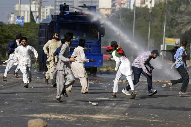 Police use a water cannon to disperse supporters of Pakistan's former Prime Minister Imran Khan protesting against the arrest of their leader, in Karachi, Pakistan, Tuesday, May 9, 2023.  Khan was arrested Tuesday as he appeared in a court in the country’s capital, Islamabad, to face charges in multiple graft cases. Security agents dragged Khan outside and shoved him into an armored car before whisking him away. (Photo by Fareed Khan/AP Photo)