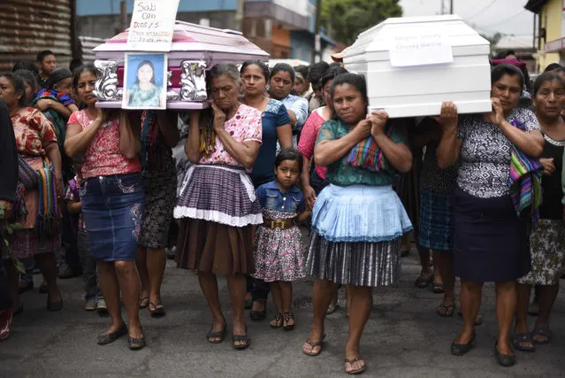 People carry the coffins of two victims of the Fuego Volcano along the streets of Alotenango municipality, Sacatepequez, about 65 km southwest of Guatemala City, during the funeral of four of the at least 109 confirmed victims on June 10, 2018. A week after Guatemala' s Fuego volcano eruption the death toll has reached 109, leaving dozens of people injured and more than 12,000 evacuated, with over 3,600 in shelters, according to figures from the country' s disaster agency. (Photo by  Johan Ordonez/AFP Photo)