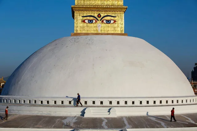 Nepales workers walks around the dome of Nepal's Boudha stupa after reconstruction is completed in Kathmandu, Nepal, 07 November 2016. The dome-shaped stupa, a major tourist attraction in Kathmandu, was sustained damage on its upper portion in the earthquake in 2015. The reconstruction of the shrine, which was made by community effort, cost around 2.15 million US dollars and about 1.41 million US dollars was spent for the gold needed to mold the upper part of the shrine. (Photo by Narendra Shrestha/EPA)