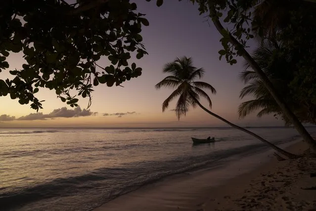 A boat navigates the shore of the island of Tobago, Trinidad and Tobago, at sunset on Sunday, January 23, 2022. (Photo by Felipe Dana/AP Photo)