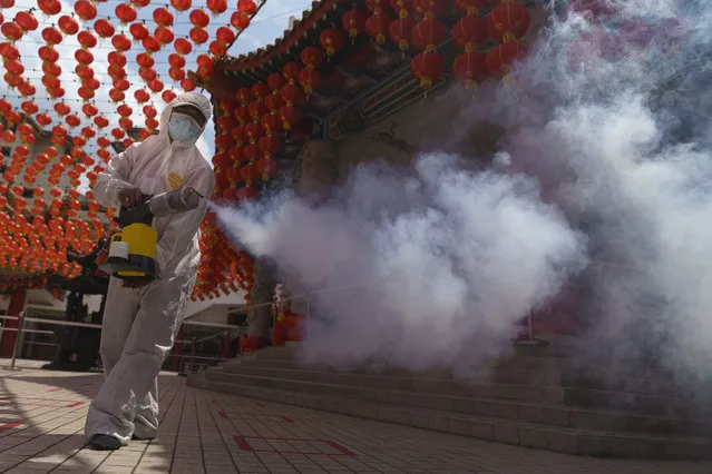 A worker disinfects the Thean Hou Temple during during first day of Chinese Lunar New Year celebrations in Kuala Lumpur, Friday, February 12, 2021. The movement control order (MCO) currently enforced across the country to help curb the spread of the coronavirus, has been extended to Feb. 18, effectively covering the Chinese New Year festival that falls on Feb. 12 this year. (Photo by Vincent Thian/AP Photo)