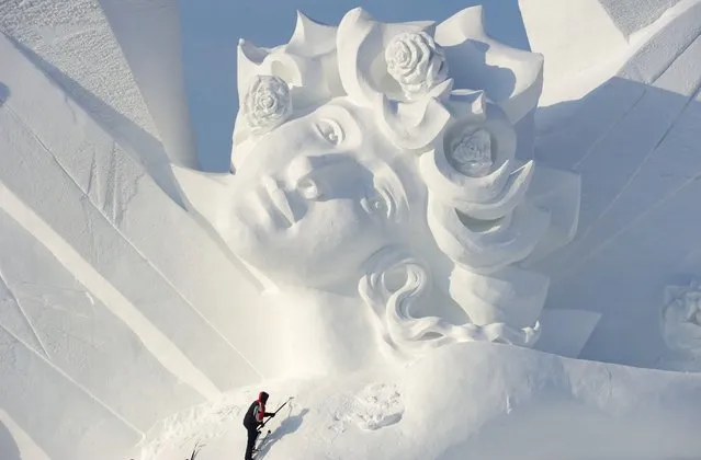A worker carves a large snow sculpture at the Sun Island Park during the 28th China Harbin International Snow Sculpture Art Expo in Harbin, Heilongjiang province, China, December 17, 2015.This expo displays will official open in Dec. 20, 2015. (Photo by Tao Zhang/NurPhoto via ZUMA Press)