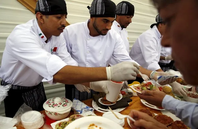Mexican inmates serve food to guests during a Christmas event at Sarita Colonia male prison in Callao, Peru, December 18, 2015. (Photo by Mariana Bazo/Reuters)