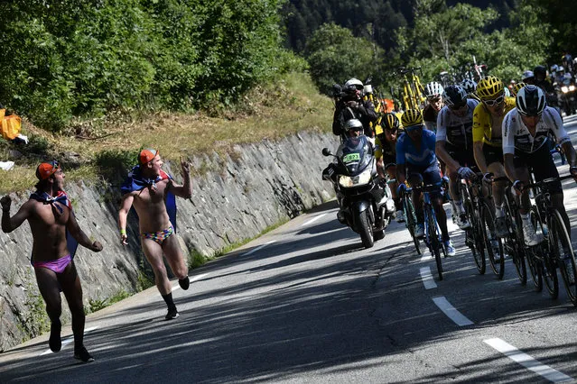 Spectators run along (From R) Colombia's Egan Bernal, Great Britain's Geraint Thomas, wearing the overall leader's yellow jersey, Great Britain's Christopher Froome, France's Romain Bardet (Rear) and Colombia's Nairo Quintana as they ride in the ascent to l'Alpe d'Huez during the twelfth stage of the 105th edition of the Tour de France cycling race, between Bourg-Saint-Maurice - Les Arcs and l'Alpe d'Huez, on July 19, 2018. (Photo by Jeff Pachoud/AFP Photo)