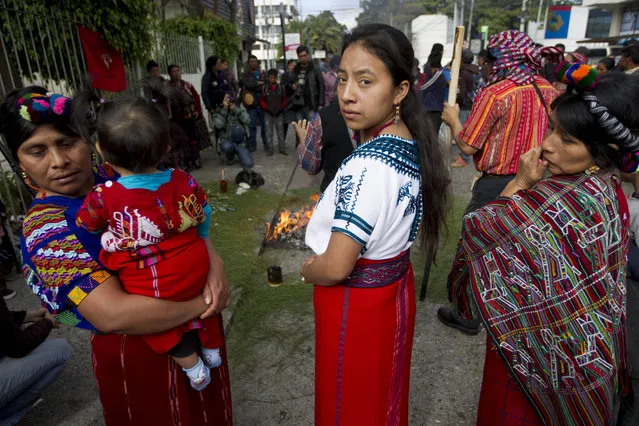 Mayan women take part in a spiritual ritual honoring the victims who died 35 years ago in a police raid of the former Spanish embassy, on the site where the embassy once stood, in Guatemala City, Saturday, January 31, 2015. A Guatemalan court recently found former police chief Pedro Garcia Arredondo guilty of ordering the Jan. 31, 1980 attack on the embassy in which 37 people died, sentencing him to 90 years in prison. (Photo by Moises Castillo/AP Photo)