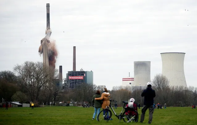 People watch as a former power plant is destroyed via controlled explosion in Luenen, Germany on March 28, 2021. (Photo by Leon Kuegeler/Reuters)