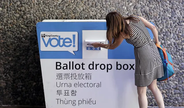 A voter places her ballot into a drop box Tuesday, August 7, 2018, in Seattle. Washington voters will decide which candidates advance to the November ballot in 10 congressional races, a U.S. Senate seat and dozens of legislative contests in the state's primary election Tuesday. (Photo by Elaine Thompson/AP Photo)
