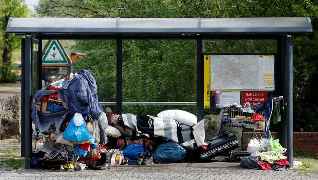 A homeless man sleeps amongst his possessions inside a bus stop at Berlin's Kreuzberg district, April 8, 2014. (Photo by Fabrizio Bensch/Reuters)