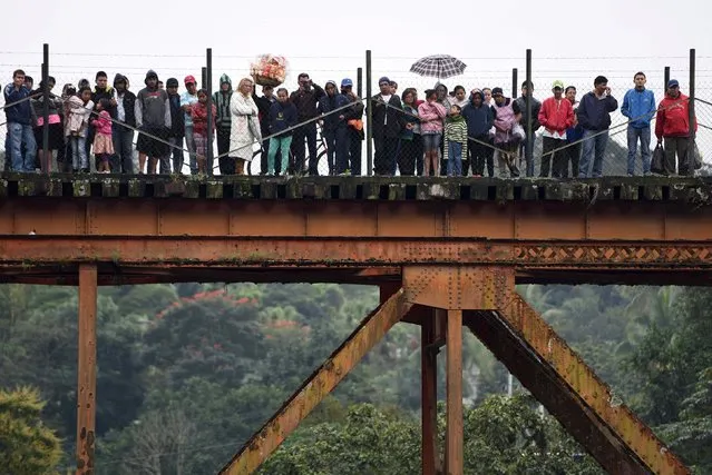 Onlookers watch as rescuers search for victims at the crash site of a bus which ran off a highway bridge in Atoyac in Veracruz state, Mexico, January 10, 2016. (Photo by Yahir Ceballos/Reuters)