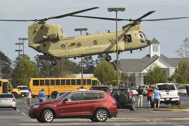 A National Guard Chinook helicopter lands in Hanover Shopping Center off Oleander Drive in Wilmington, N.C., Tuesday September 18, 2018. The Chinook was delivering supplies for the continuing relief efforts after Hurricane Florence hit the Wilmington area. (Photo by Ken Blevins/The Star-News via AP Photo)