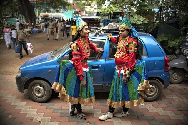 Two folk artists chat as they wait to participate in a procession marking 'Atham', the first day of ten-days long Onam festival in Kochi, Kerala state, India, Sunday, August 20, 2023. (Photo by R.S. Iyer/AP Photo)