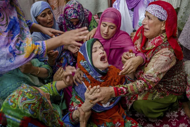 Ruksana Nazir, center, is comforted during the funeral of her husband Nazir Ahmed Wani in Srinagar, Indian controlled Kashmir, Friday, October 5, 2018. Suspected rebels on Friday shot and killed two activists, which included Wani, affiliated with a pro-India Kashmiri political group in the disputed region's main city, officials said. (Photo by Dar Yasin/AP Photo)