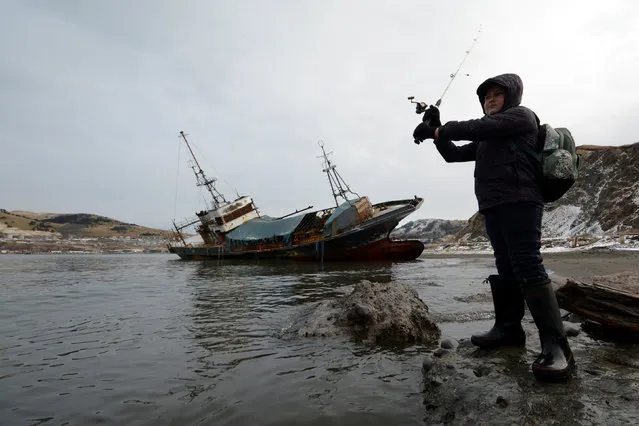 A boy fishes on the banks of Malokurilskaya Bay in the village of Malokurilskoye on the island of Shikotan, Southern Kuriles, Russia, December 18, 2016. (Photo by Yuri Maltsev/Reuters)