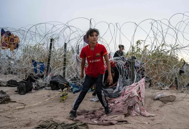 Chelsea from Nicaragua looks on after crawling through a hole made in the razor wire to cross into Eagle Pass, Texas on September 25, 2023. Dozens of migrants arrived at the US-Mexico border on September 22, 2023, hoping to be allowed into the United States, with US border forces reporting 1.8 million encounters with migrants in the last 12 months. (Photo by Andrew Caballero-Reynolds/AFP Photo)