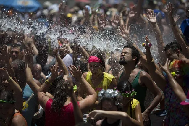People cool off in water during the “Escravos da Maua” block party, as part of pre-Carnival celebrations in Rio de Janeiro, Brazil, Sunday, January 31, 2016. (Photo by Leo Correa/AP Photo)