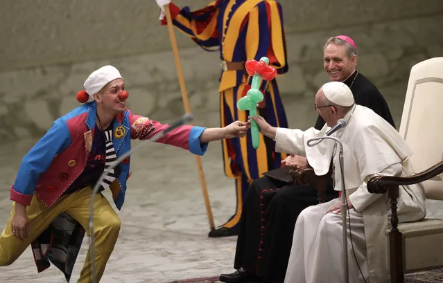 Pope Francis receives an balloon flower during a performance of the Golden Circus in the Paul VI Hall at the Vatican at the end of his weekly general audience Wednesday, December 28, 2016. (Photo by Alessandra Tarantino/AP Photo)