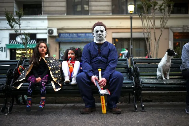 Children and adults in costumes go trick-or-treating on Halloween in Santiago, Chile on October 31, 2023. (Photo by Pablo Sanhueza/Reuters)