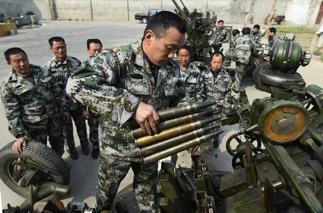 Militia members practice firing artillery shells to create artificial rainfall in Zouping county in eastern China's Shandong province, Wednesday, March 25, 2015. An ongoing drought in the region has led officials to plan to start using cloud seeding in April to help boost the annual wheat crop. (Photo by AP Photo/Stringer)