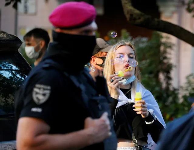 An activist blows soap bubbles as she attends a rally to support anti-government movement, one year after disputed election of the Belarusian president next to the Belarusian Embassy in central Kyiv, Ukraine August 8, 2021. (Photo by Gleb Garanich/Reuters)