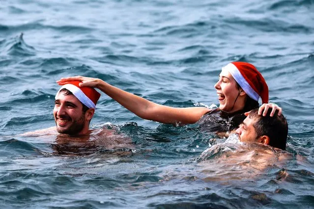 People wearing Santa Claus hats take part in the Santa Swim in aid of charity at the marina of the Grand Hotel Excelsior in Floriana, Malta on December 3, 2023. (Photo by Darrin Zammit Lupi/Reuters)