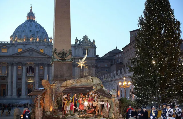The crib scene next to a Christmas tree in St Peter's Square at the Vatican, 24 December 2013 ahead of Pope Francis' appearance for the traditional midnight mass. (Photo by Alessandro Di Meo/EPA)
