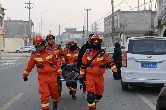 Rescue workers carry an injured person on a stretcher at Dahejia town following the earthquake in Jishishan county, Gansu province, China on December 19, 2023. (Photo by cnsphoto via Reuters)