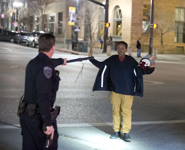 Police stop a boy as he walks away from a crowd that formed after an officer-involved shooting at 200 South Rio Grande Street in Salt Lake City, Saturday, February 27, 2016. Unrest broke out in a Salt Lake City neighborhood on Saturday night after what appears to be a shooting involving a police officer, the Salt Lake Tribune reported. (Photo by Lennie Mahler/The Salt Lake Tribune via AP Photo)