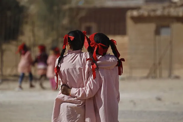Indigenous Sahrawi girls hug each other beside their school in a refugee camp of Boudjdour in Tindouf, southern Algeria March 3, 2016. (Photo by Zohra Bensemra/Reuters)