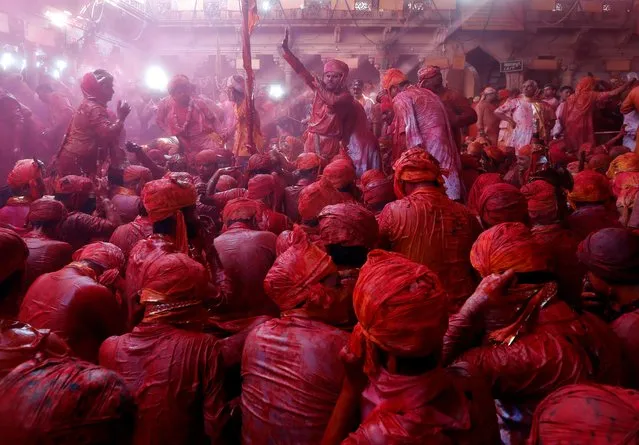 Men daubed in colours sing hymns and dance as they take part in “Lathmar Holi” celebrations inside a temple in the town of Barsana, in Uttar Pradesh, India, March 15, 2019. (Photo by Altaf Hussain/Reuters)