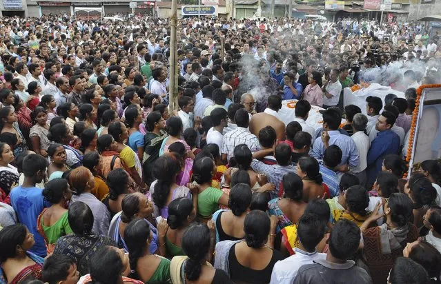 People stand amid coffins of the victims of Saturday's earthquake in Nepal, during the funeral in Guwahati, India, April 29, 2015. (Photo by Utpal Baruah/Reuters)