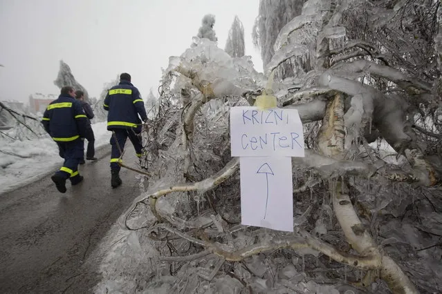 Firefighters walk to a crisis centre in Postojna February 5, 2014.  The sign reads “Crisis Centre”. (Photo by Srdjan Zivulovic/Reuters)