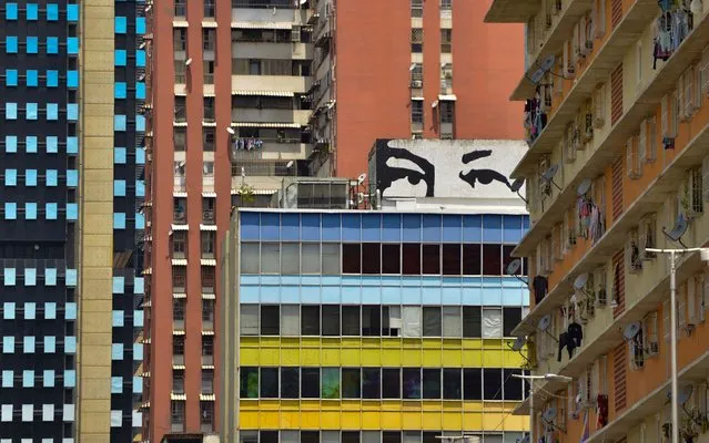 View of a mural depicting late Venezuelan President Hugo Chavez in Caracas, on March 10, 2019. Sunday is the third day Venezuelans remain without communications, electricity or water, in an unprecedented power outage that already left 15 patients dead and threatens with extending indefinitely, increasing distress for the severe political and economic crisis hitting the oil-rich South American nation. (Photo by Matias Delacroix/AFP Photo)