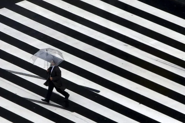 A pedestrian holding an umbrella crosses a street at a shopping district in Tokyo, Japan, March 7, 2016. (Photo by Yuya Shino/Reuters)