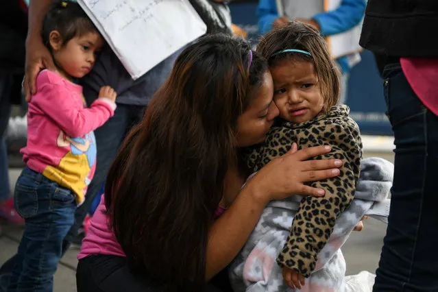 Roselin, an asylum seeker from Honduras, comforts two year-old daughter Julieth as they wait with other migrant families recently released from detention to board a bus in McAllen, Texas, U.S., May 16, 2019. (Photo by Loren Elliott/Reuters)