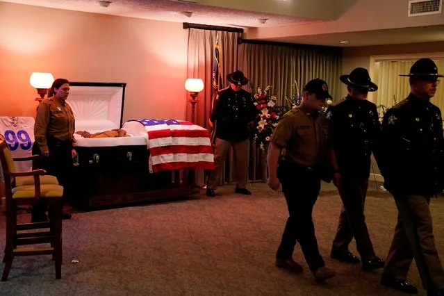 Officers visit the casket of corrections officer Robert Daniel which lies open at the Brown Funeral Home in Mayfield, Kentucky, U.S., December 18, 2021. Officer Daniel was killed on December 10 while directing workers and inmates under his care to safety following a devastating outbreak of tornadoes that ripped through several U.S. states. (Photo by Cheney Orr/Reuters)