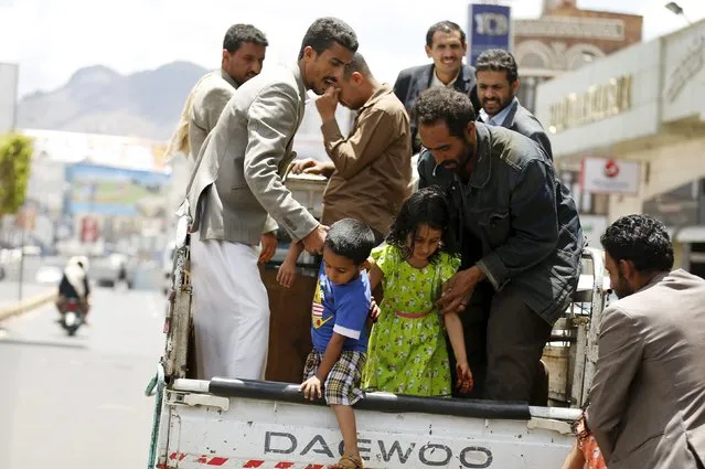 People help children step out of a truck taxi in Yemen's capital Sanaa May 6, 2015. (Photo by Khaled Abdullah/Reuters)