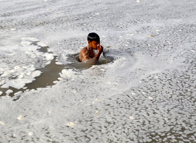 A Hindu devotee takes a dip in the polluted water of the Ganges river in Allahabad, India, July 5, 2015. (Photo by Jitendra Prakash/Reuters)