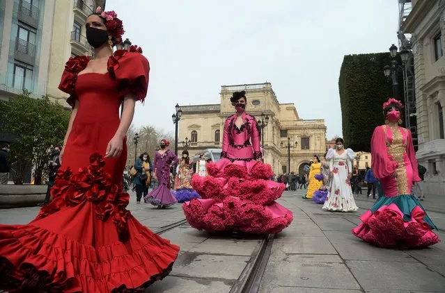 Models and dancers dressed in flamenco dresses march during a protest to shed light on the difficulties the flamenco fashion sector is facing over coronavirus restrictions, in Seville on February 26, 2021. (Photo by Cristina Quicler/AFP Photo)