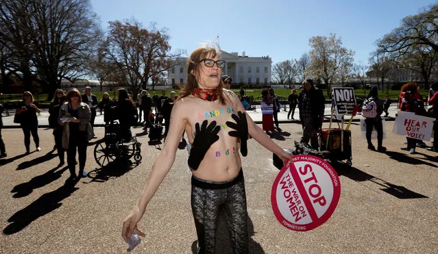 A protester wears a pair of gloves over her breasts as she and hundreds of other activists demonstrate outside the White House as part of “A Day Without a Woman” strike on International Women's Day in Washington, March 8, 2017. (Photo by Kevin Lamarque/Reuters)