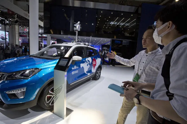 A promoter from Baidu talk about the vehicle used to capture images for their mapping services displayed at Auto China 2016 in Beijing, China, Monday, April 25, 2016. (Photo by Ng Han Guan/AP Photo)