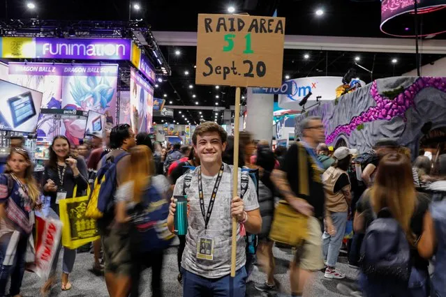An attendee holding a sign walks the convention floor at Comic Con International in San Diego, California, U.S., July 19, 2019. (Photo by Mike Blake/Reuters)