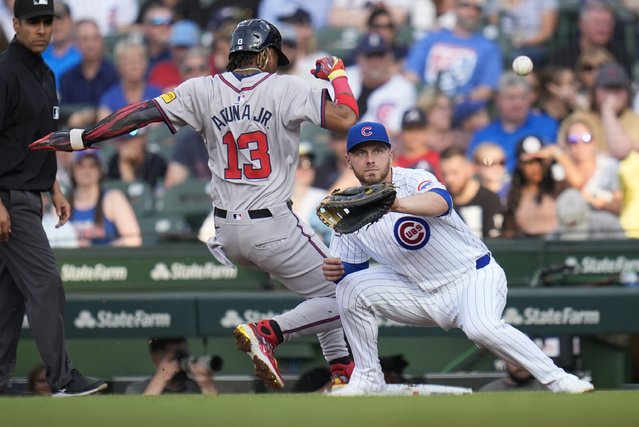 Chicago Cubs starting pitcher Javier Assad throws to first baseman Michael Busch trying to force out Atlanta Braves' Ronald Acuña Jr. during the first inning of a baseball game Tuesday, May 21, 2024, in Chicago. (Photo by Erin Hooley/AP Photo)