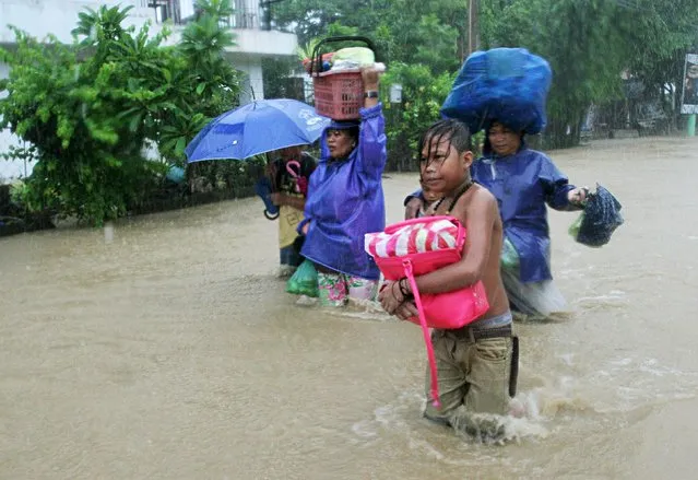 Residents wade along a flooded road after tropical storm Linfa hit San Fernando, La Union in northern Philippines July 5, 2015. (Photo by T. J. Corpuz/Reuters)