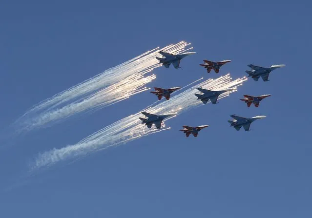 MiG-29 jet fighters of the Strizhi (Swifts) and Su-27 jet fighters of the Russkiye Vityazi (Russian Knights) aerobatic teams fly in formation during the Victory Day parade, marking the 71st anniversary of the victory over Nazi Germany in World War Two, above Red Square in Moscow, Russia, May 9, 2016. (Photo by Grigory Dukor/Reuters)