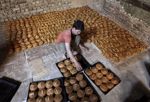 A vendor prepare cookies for customers ahead of Eid al-Fitr, which marks the end of Ramadan, in Mazar-i-Sharif, Afghanistan July 13, 2015. (Photo by Anil Usyan/Reuters)