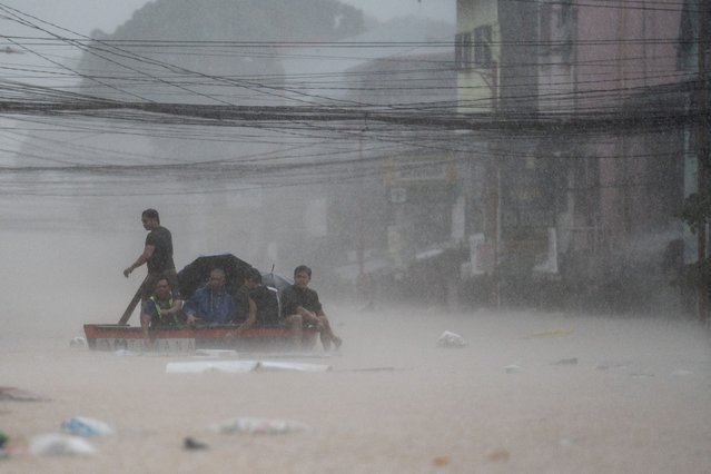 Rescuers assist residents on a boat along a flooded road following heavy rains brought by Typhoon Gaemi, in Marikina City, Metro Manila, Philippines, on July 24, 2024. (Photo by Lisa Marie David/Reuters)