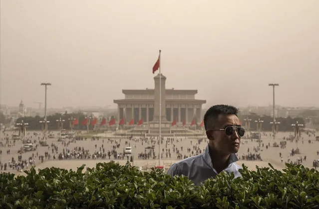 A Chinese police officer stands guard during a sandstorm overlooking Tiananmen Square on May 4, 2017 in Beijing, China. Sandstorms are common in northern China during the spring season and are caused when heavy winds from Mongolia in the north brings sand and pollutants that can blanket Chinese cities and cause air quality to deteriorate. (Photo by Kevin Frayer/Getty Images)