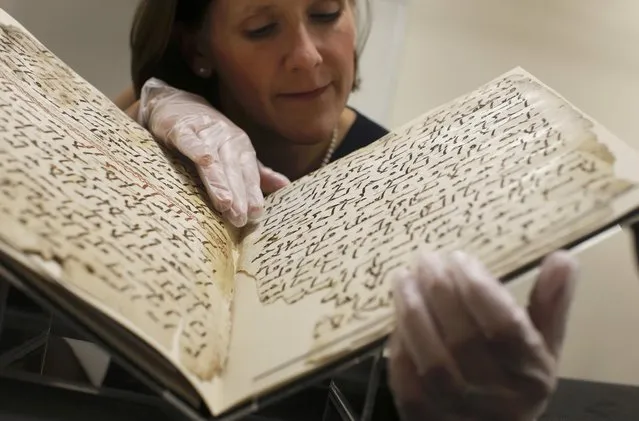 Conservator, Marie Sviergula holds a fragment of a Koran manuscript in the library at the University of Birmingham in Britain July 22, 2015. (Photo by Peter Nicholls/Reuters)